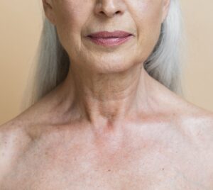 Bella donna matura, con i capelli lunghi e bianchi sciolti sulle spalle nude, visibile dal collo in giù.