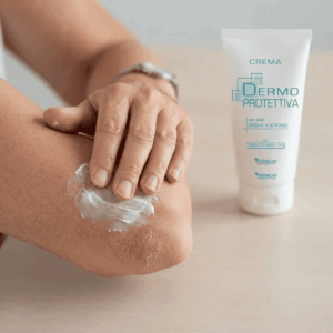 Primo piano della mano di un uomo che si spalma la crema dermoprotettiva Faramazan sul suo gomito screpolato
