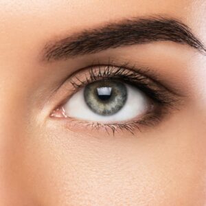 Primo piano di uno splendido occhio verde femminile con sopracciglio molto curato e trucco leggero.
